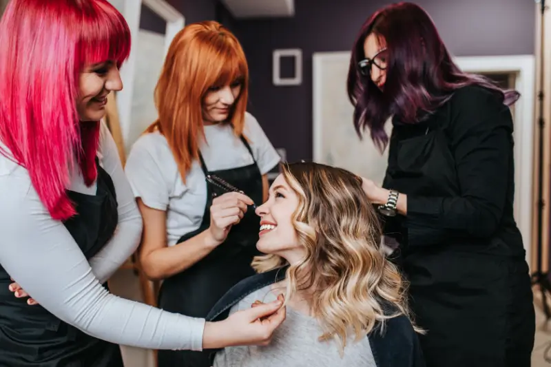 Stylists working on a client's blonde balayage